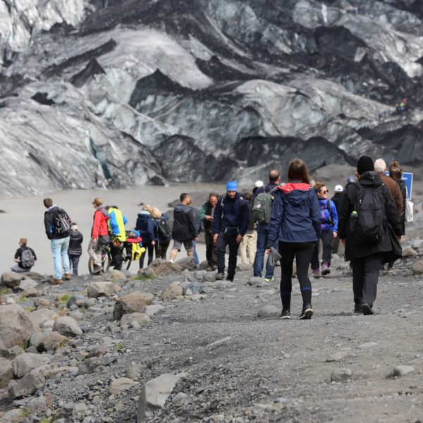 Landausfluggäste spazieren am Gletscher Sólheimajökull