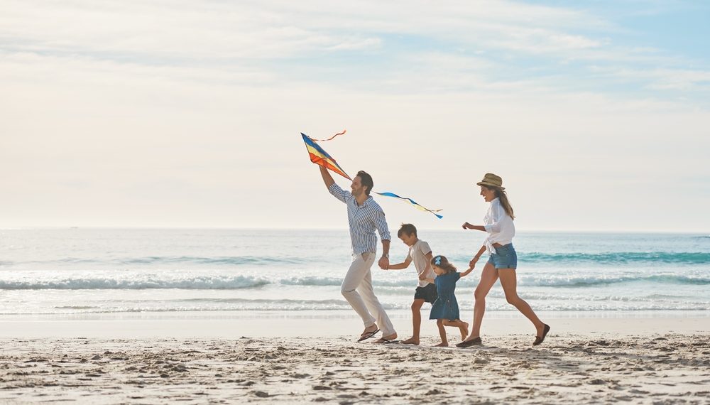 Familie am Strand mit Drachen