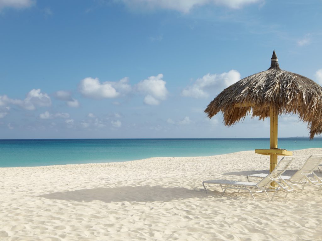 Liegestühle und Sonnenschutz am berühmten Eagle Beach auf Aruba