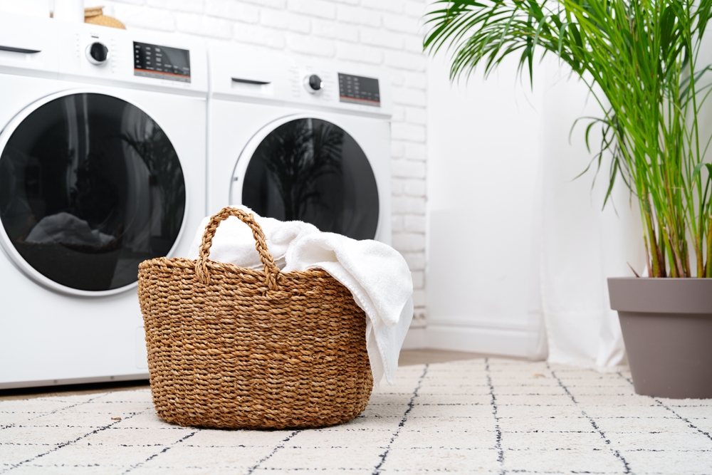 Ein Wäschekorb steht vor zwei Waschmaschinen