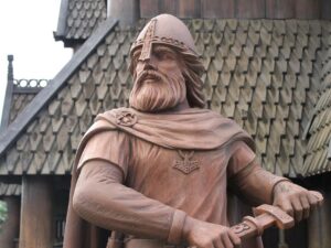 Holzstatue von einem Wikinger vor einer Kirche