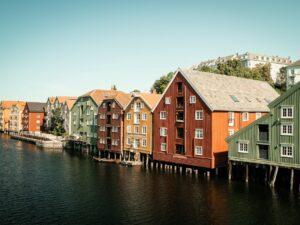 Die bunten Häuser Bryggene spiegeln sich im Fluss Nidelva wieder