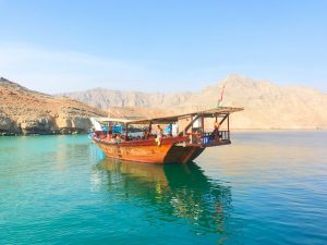 Landausflugsgäste genießen eine Bootsfahrt auf einer traditionellen orientalischen Dhau