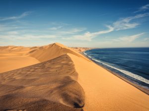 Große Sanddünen grenzen direkt an das Meer in Sandwich Harbour