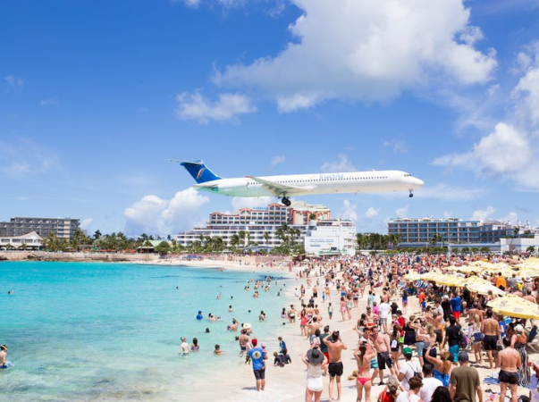 Flugzeug fliegt über den Maho Beach